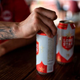 Person with tattoos opening can of Lone Star Beer